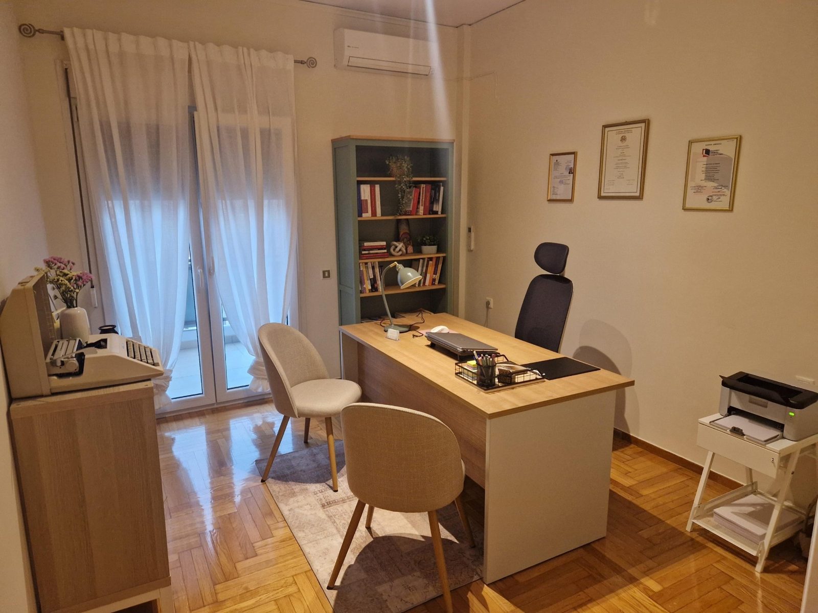 Επαγγελματικός χώρος γραφείου με βιβλιοθήκη και πτυχία